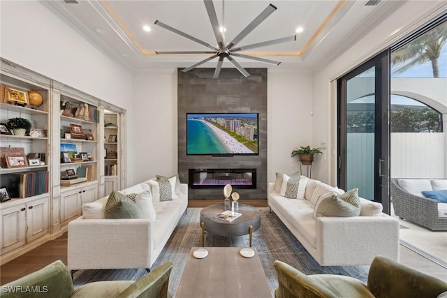 living area with dark wood-type flooring, recessed lighting, a fireplace, and crown molding