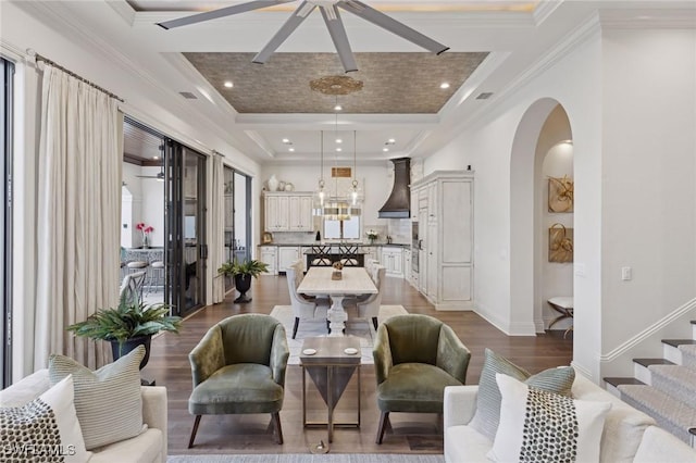 living room featuring baseboards, arched walkways, dark wood-type flooring, crown molding, and recessed lighting