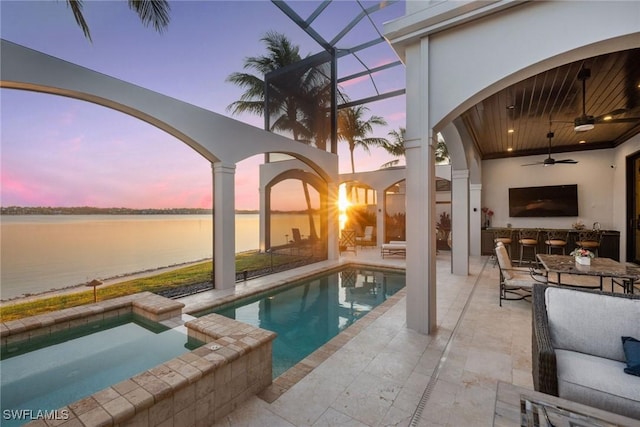 view of swimming pool with ceiling fan, a patio, a water view, and a lanai