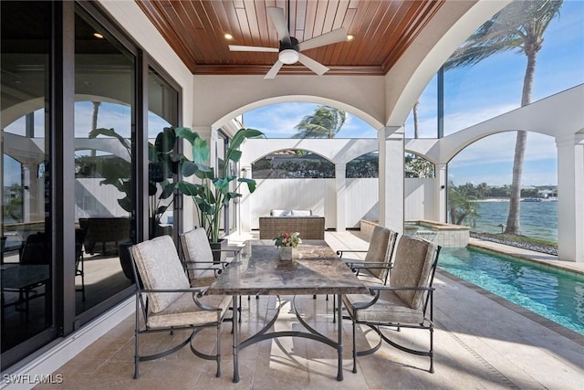 sunroom with a water view, wood ceiling, and ceiling fan