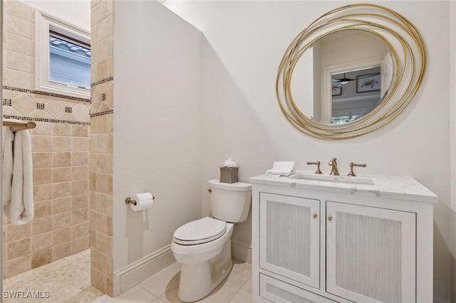 bathroom with tile patterned flooring, toilet, vanity, baseboards, and walk in shower