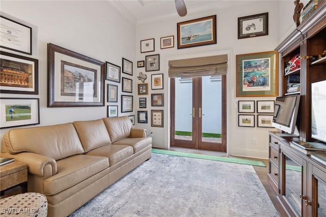 living area featuring light wood-style floors, french doors, crown molding, and baseboards