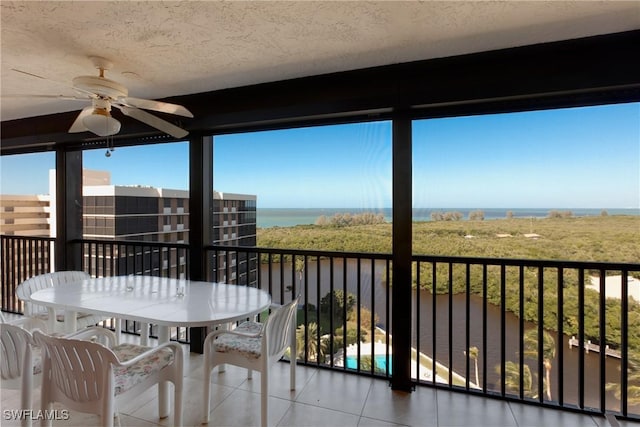 balcony featuring ceiling fan and a water view