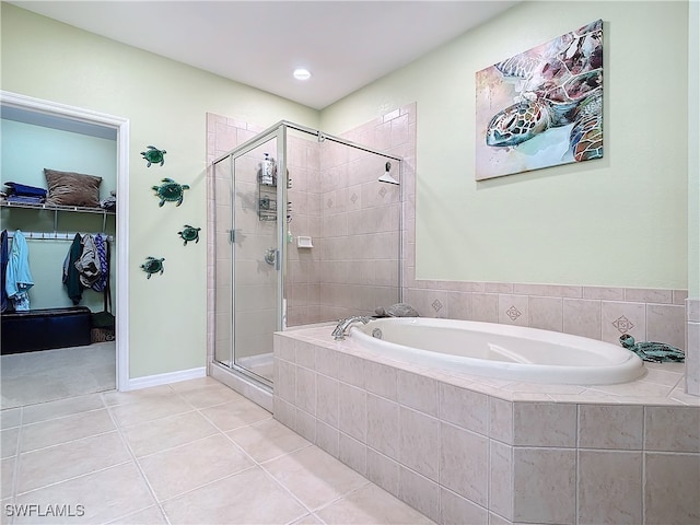 full bath with a spacious closet, a bath, a shower stall, and tile patterned flooring