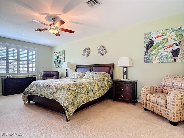 bedroom featuring visible vents, light colored carpet, and ceiling fan