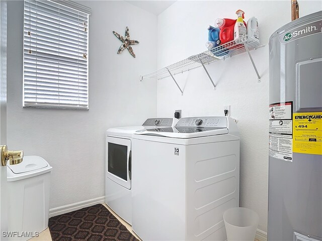 washroom with washer and dryer, laundry area, baseboards, and water heater