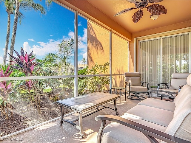 sunroom / solarium featuring a ceiling fan