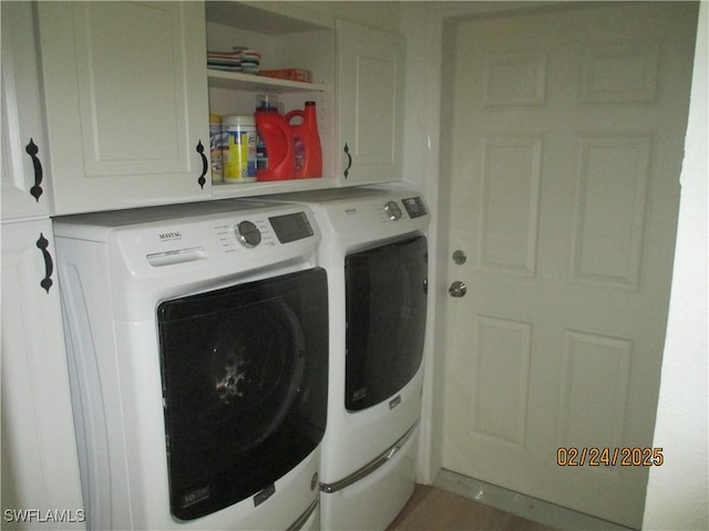 clothes washing area featuring washing machine and dryer and cabinet space