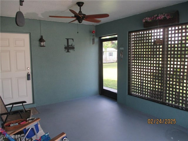 interior space featuring ceiling fan and finished concrete floors