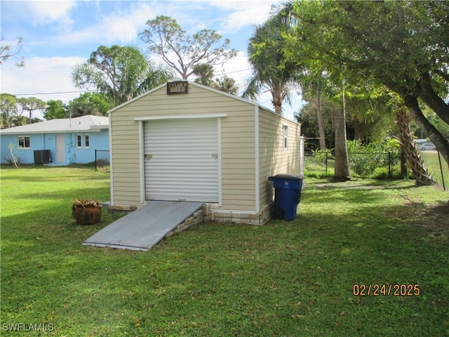 view of outdoor structure featuring central AC, an outdoor structure, and fence