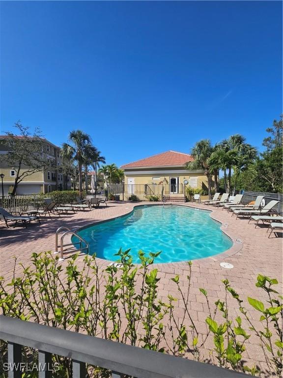 community pool featuring a patio area and fence