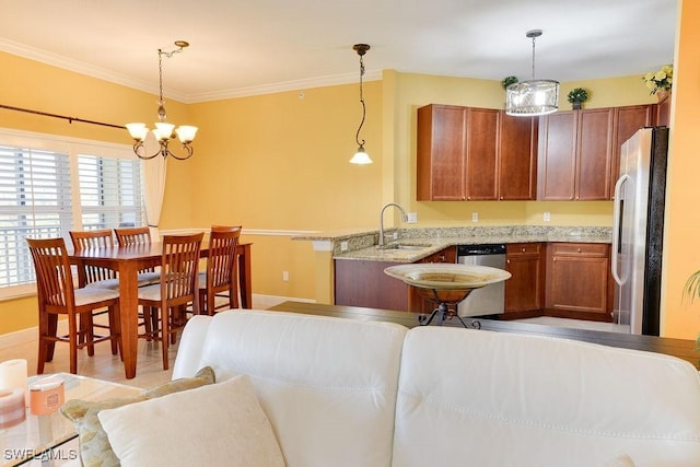 kitchen with appliances with stainless steel finishes, crown molding, a sink, and hanging light fixtures