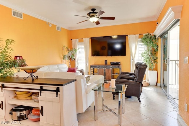 living room featuring ornamental molding, visible vents, and a ceiling fan