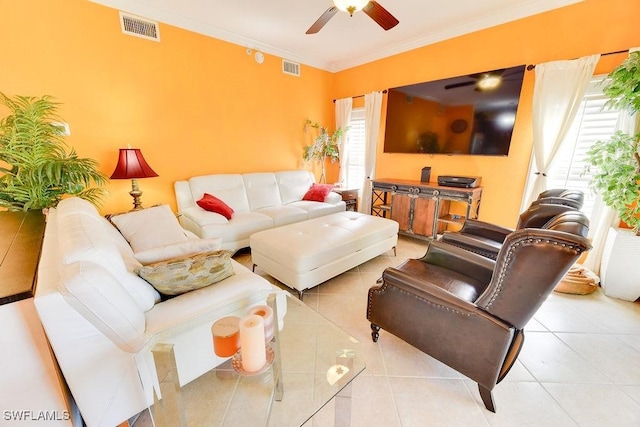 living room featuring tile patterned floors, visible vents, a ceiling fan, and ornamental molding