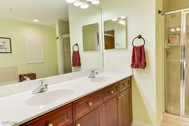 full bath with baseboards, double vanity, a sink, and a shower stall