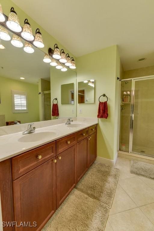 bathroom featuring double vanity, tile patterned flooring, a sink, and a shower stall