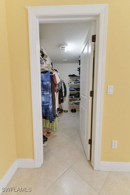 walk in closet with tile patterned flooring