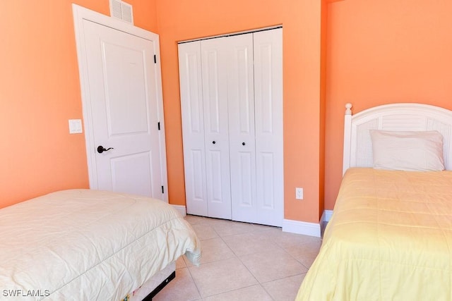 bedroom featuring baseboards, visible vents, a closet, and light tile patterned flooring