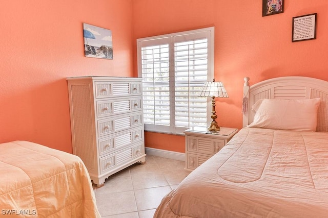 bedroom featuring baseboards and light tile patterned flooring