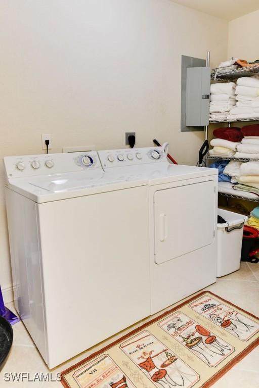 laundry room featuring light tile patterned floors, laundry area, electric panel, and washer and dryer