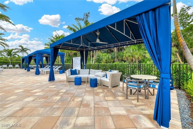 view of patio / terrace with fence, an outdoor living space, and a gazebo