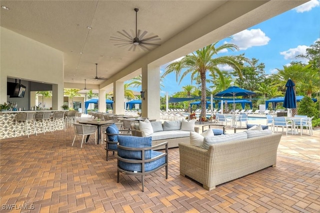 view of patio / terrace with outdoor dining area, ceiling fan, outdoor dry bar, and an outdoor hangout area