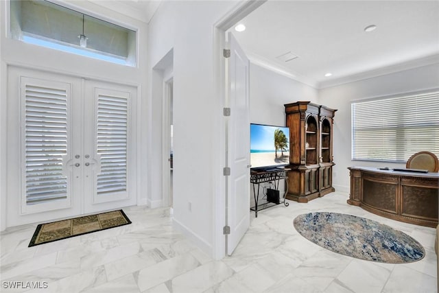 entryway featuring marble finish floor, baseboards, and crown molding