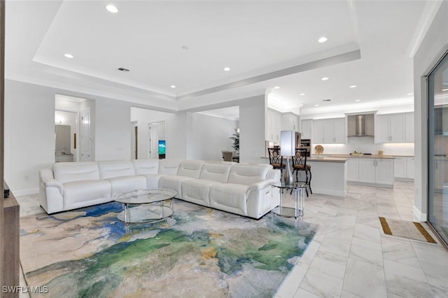 living area featuring recessed lighting, visible vents, marble finish floor, ornamental molding, and a raised ceiling