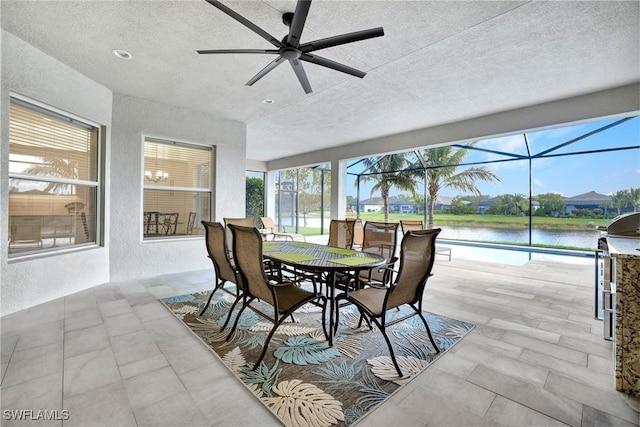 sunroom / solarium with a water view and a ceiling fan