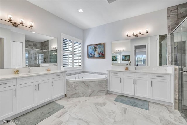 bathroom with a stall shower, two vanities, a sink, and a bath