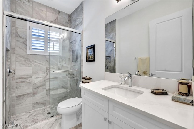 bathroom featuring a shower stall, toilet, and vanity