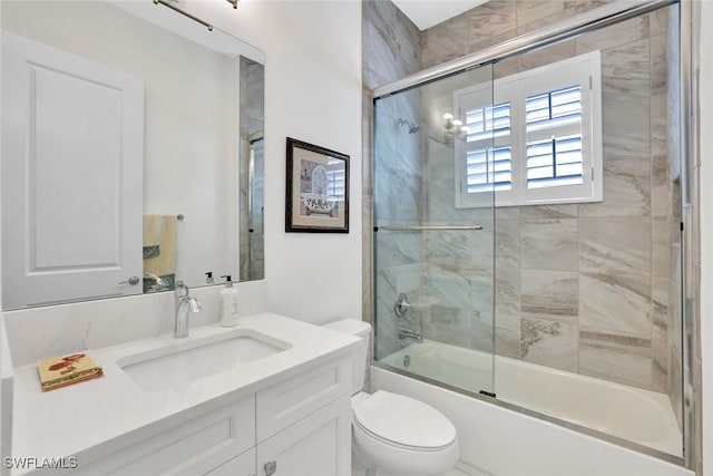 full bathroom featuring shower / bath combination with glass door, vanity, and toilet