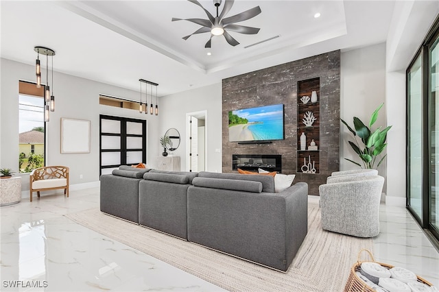 living room featuring marble finish floor, a fireplace, visible vents, and a raised ceiling