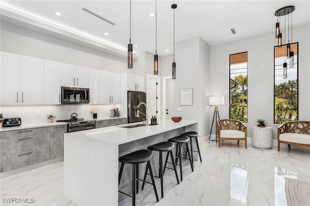 kitchen featuring stainless steel appliances, light countertops, and decorative light fixtures