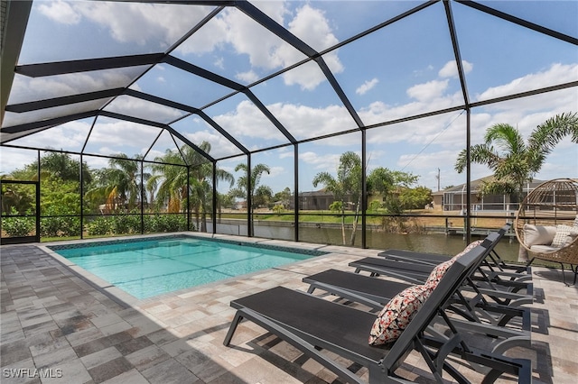 pool with a lanai, a water view, and a patio area