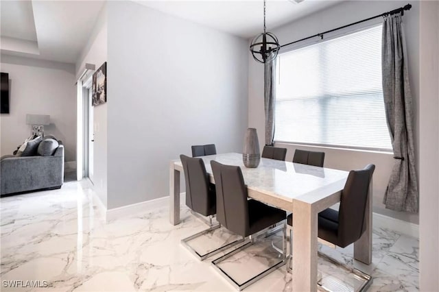 dining space with marble finish floor, baseboards, and an inviting chandelier