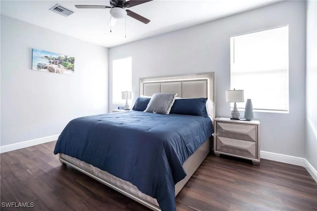 bedroom with baseboards, visible vents, dark wood finished floors, and a ceiling fan