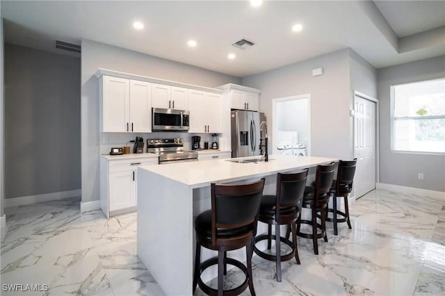 kitchen featuring visible vents, white cabinets, an island with sink, appliances with stainless steel finishes, and light countertops