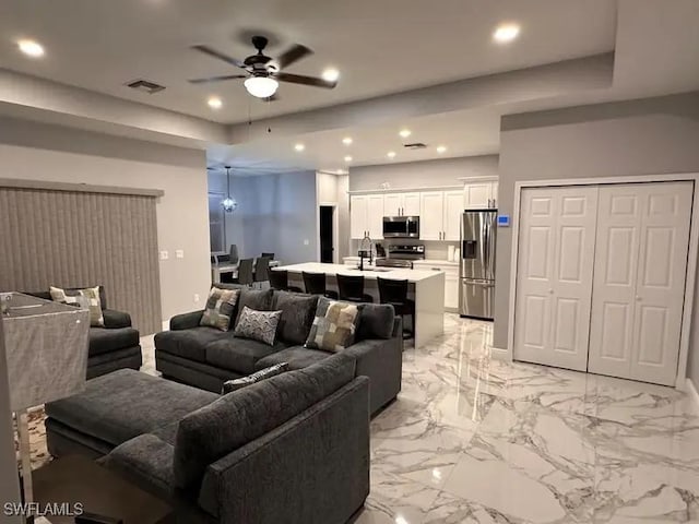 living room featuring marble finish floor, a ceiling fan, visible vents, and recessed lighting