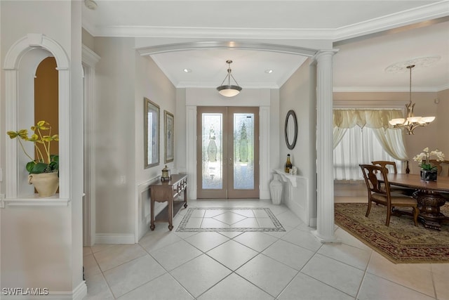 entrance foyer featuring light tile patterned floors, french doors, decorative columns, and crown molding