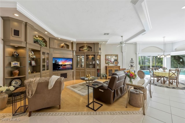 living room featuring light tile patterned floors, ceiling fan with notable chandelier, visible vents, and crown molding