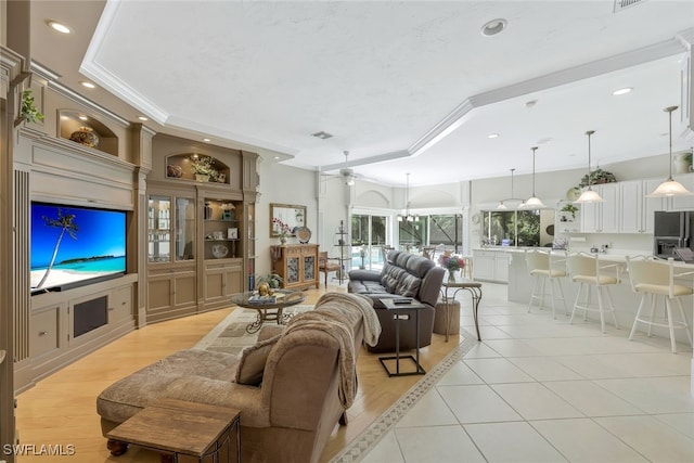 living room featuring ornamental molding, a tray ceiling, light tile patterned floors, and recessed lighting