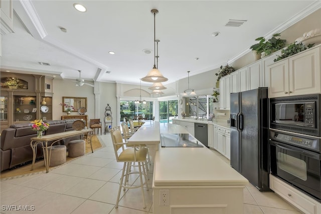 kitchen featuring ornamental molding, open floor plan, light countertops, and black appliances