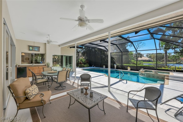 view of swimming pool featuring a patio area, a lanai, a pool with connected hot tub, and a ceiling fan