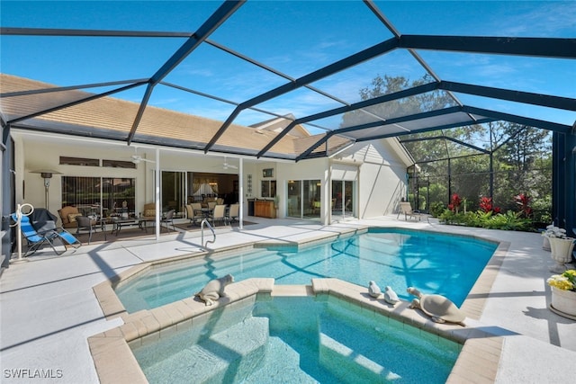 view of pool with ceiling fan, glass enclosure, a patio, and a pool with connected hot tub