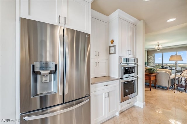 kitchen with stainless steel appliances, light countertops, white cabinetry, and recessed lighting