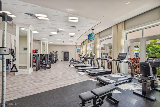 workout area featuring a drop ceiling, wood finished floors, and visible vents