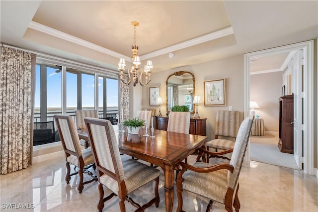 dining area with ornamental molding, a raised ceiling, and a notable chandelier