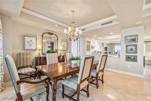 dining area with visible vents, baseboards, ornamental molding, a tray ceiling, and an inviting chandelier