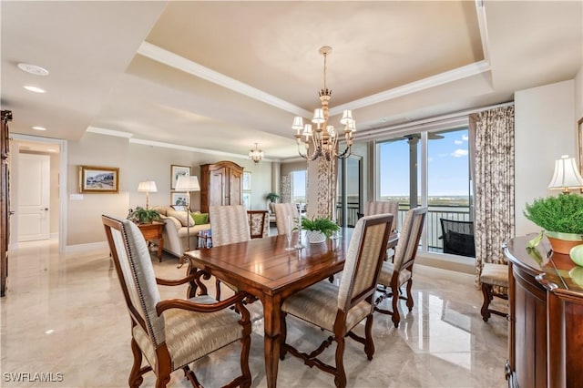 dining area featuring a notable chandelier, baseboards, marble finish floor, a raised ceiling, and crown molding